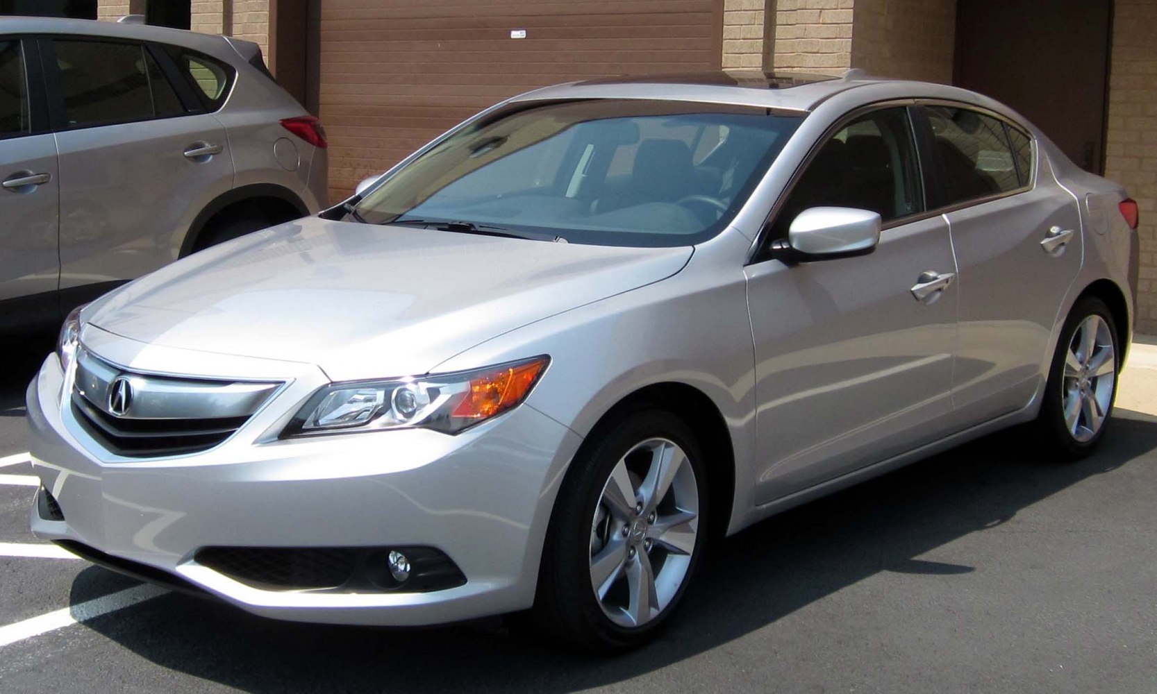 Silver sedan front-side view with sleek headlights and alloy wheels