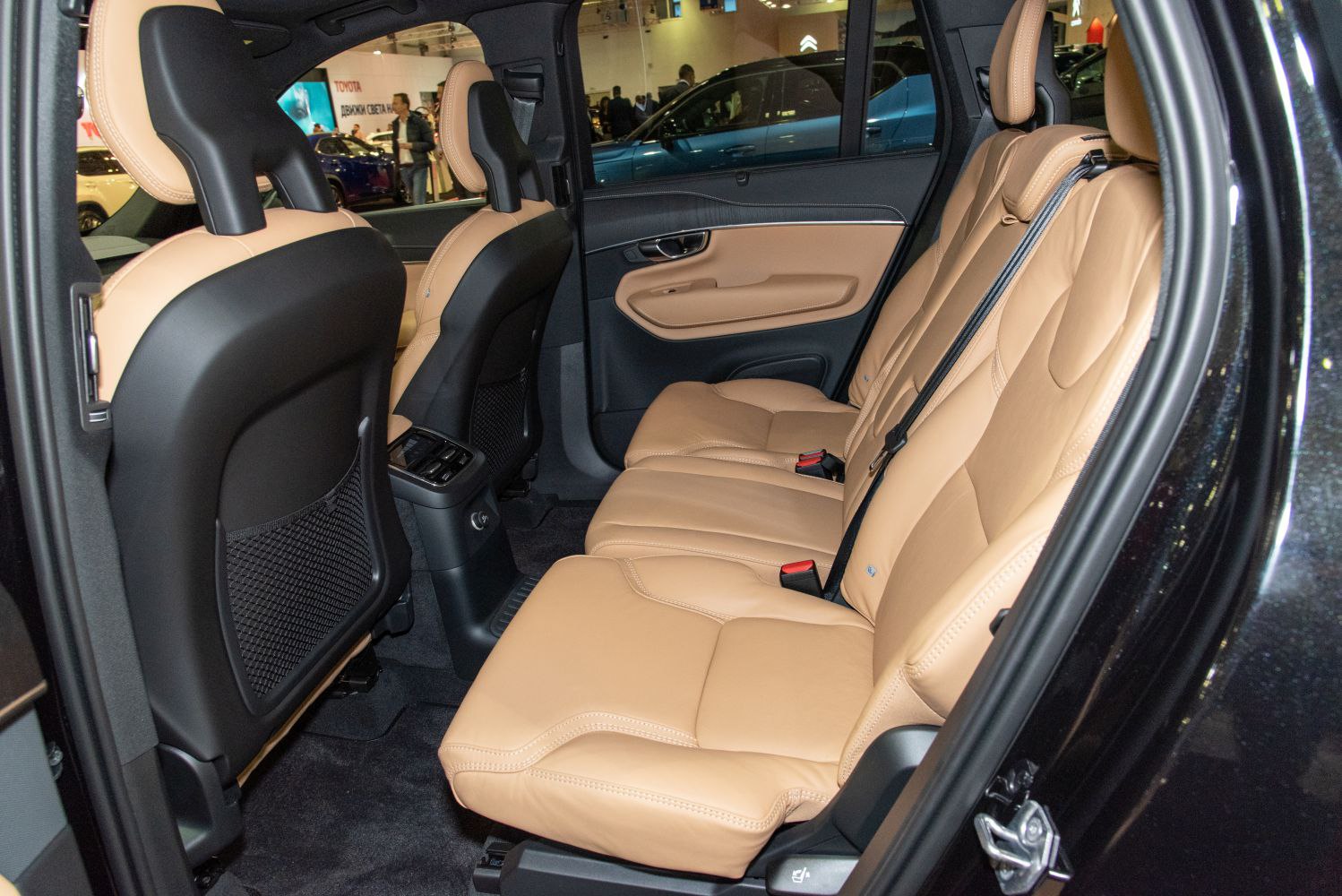 Tan leather rear passenger seats and door panel inside spacious SUV.