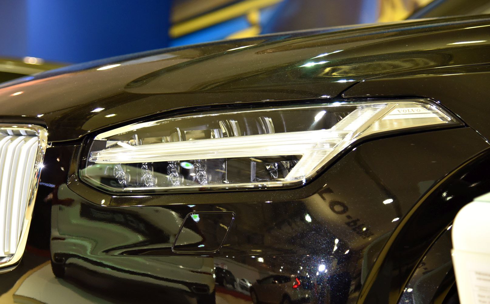 Close-up of modern LED headlight and front fender with grille edge.