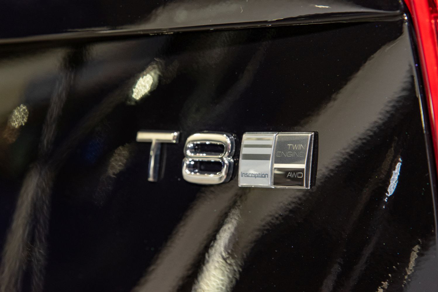 Close-up of Twin Engine Inscription AWD badge on glossy black vehicle surface
