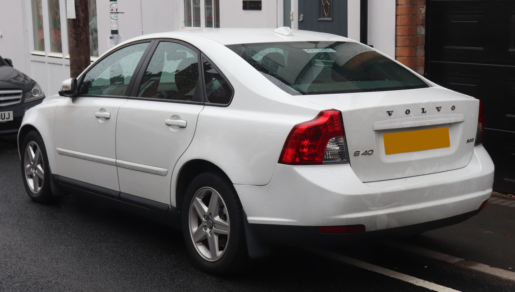 White sedan rear-side view with distinct taillights and alloy wheels