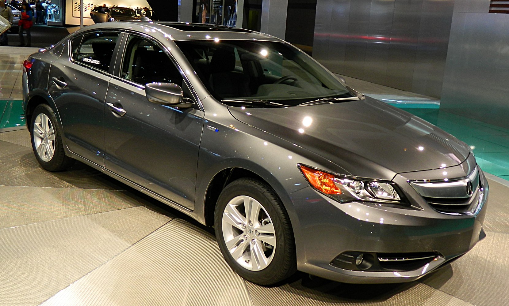 Gray sedan front-side view with sleek headlights and alloy wheels