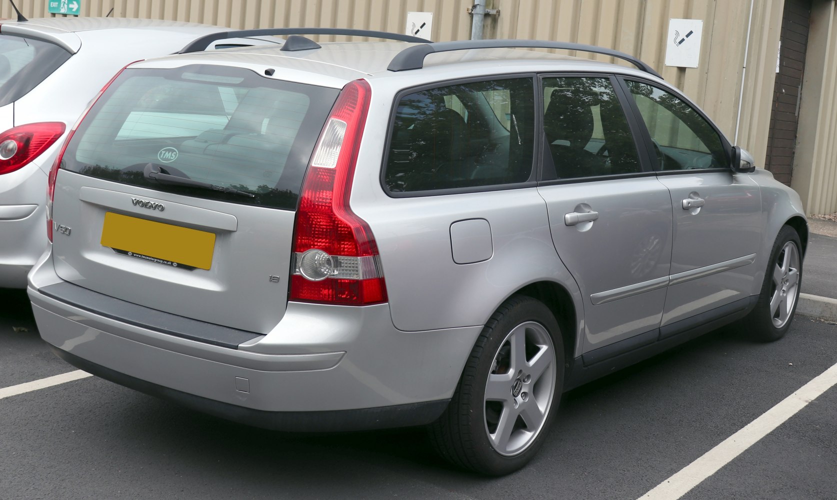 Silver estate car rear view with distinctive vertical taillights and roof rails
