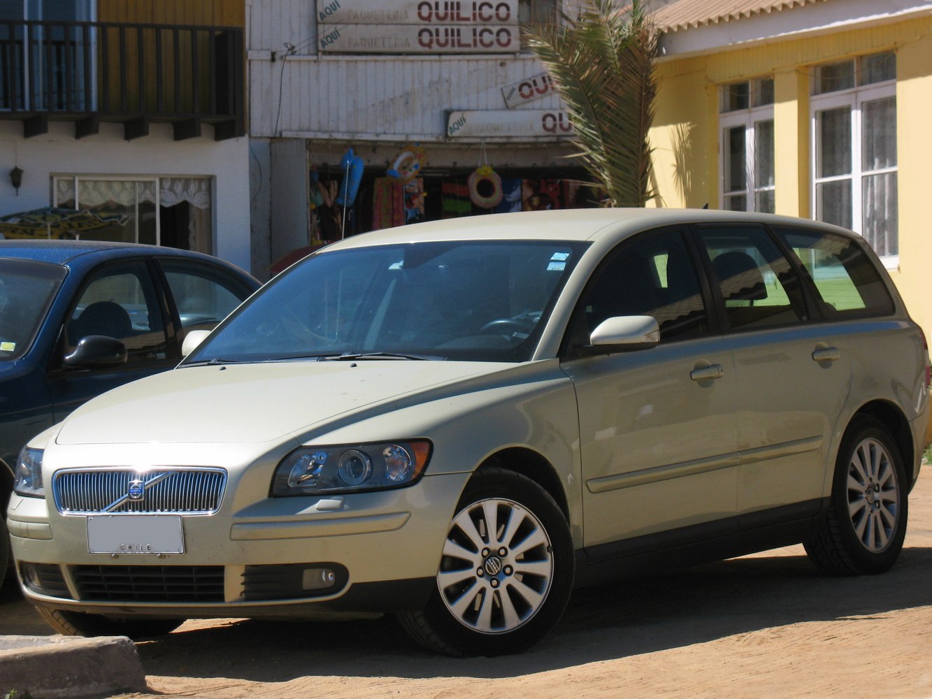 Front and side exterior view of a beige estate car with alloy wheels and distinctive headlights.