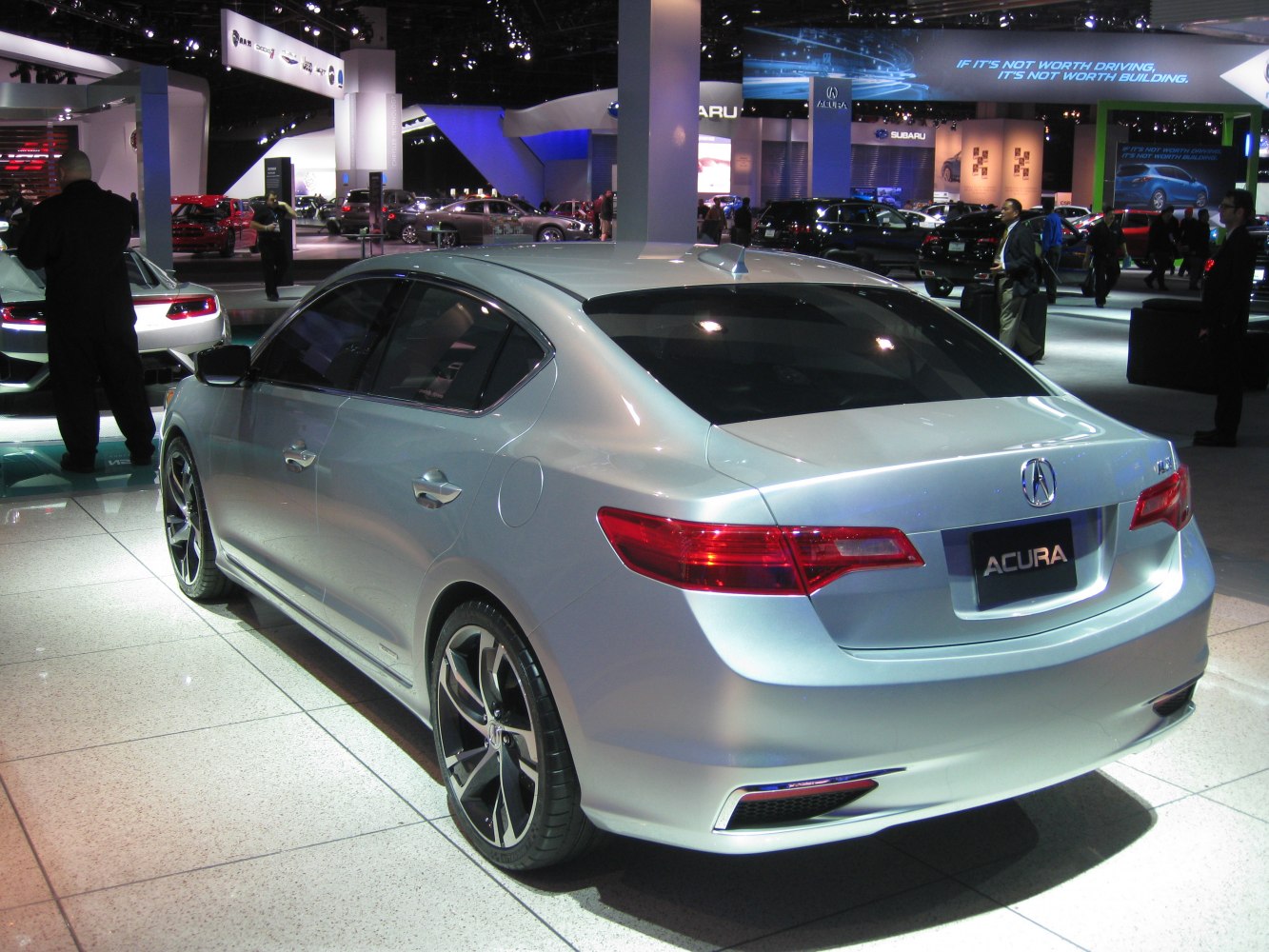 Silver sedan rear view with dark alloy wheels and sleek tail lights.