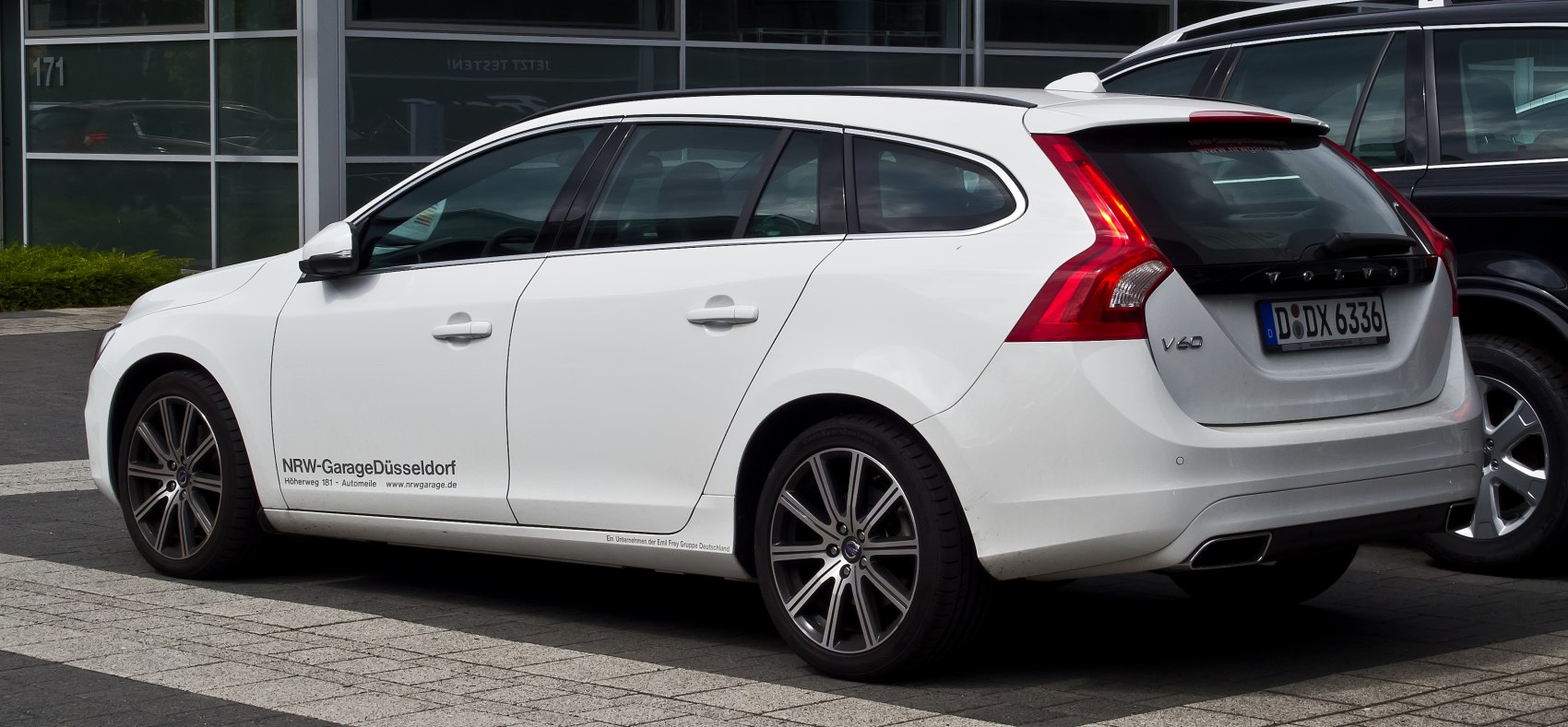 Rear-side view of a white station wagon with alloy wheels and modern tail lights