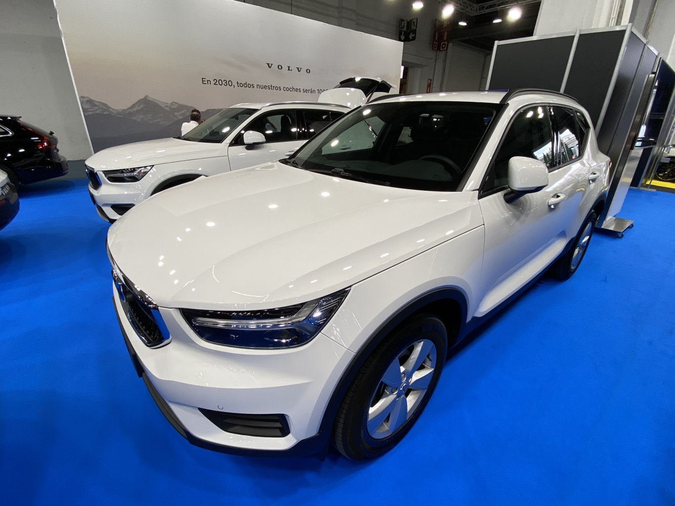 White compact SUV with LED headlights, front and side angles on blue flooring