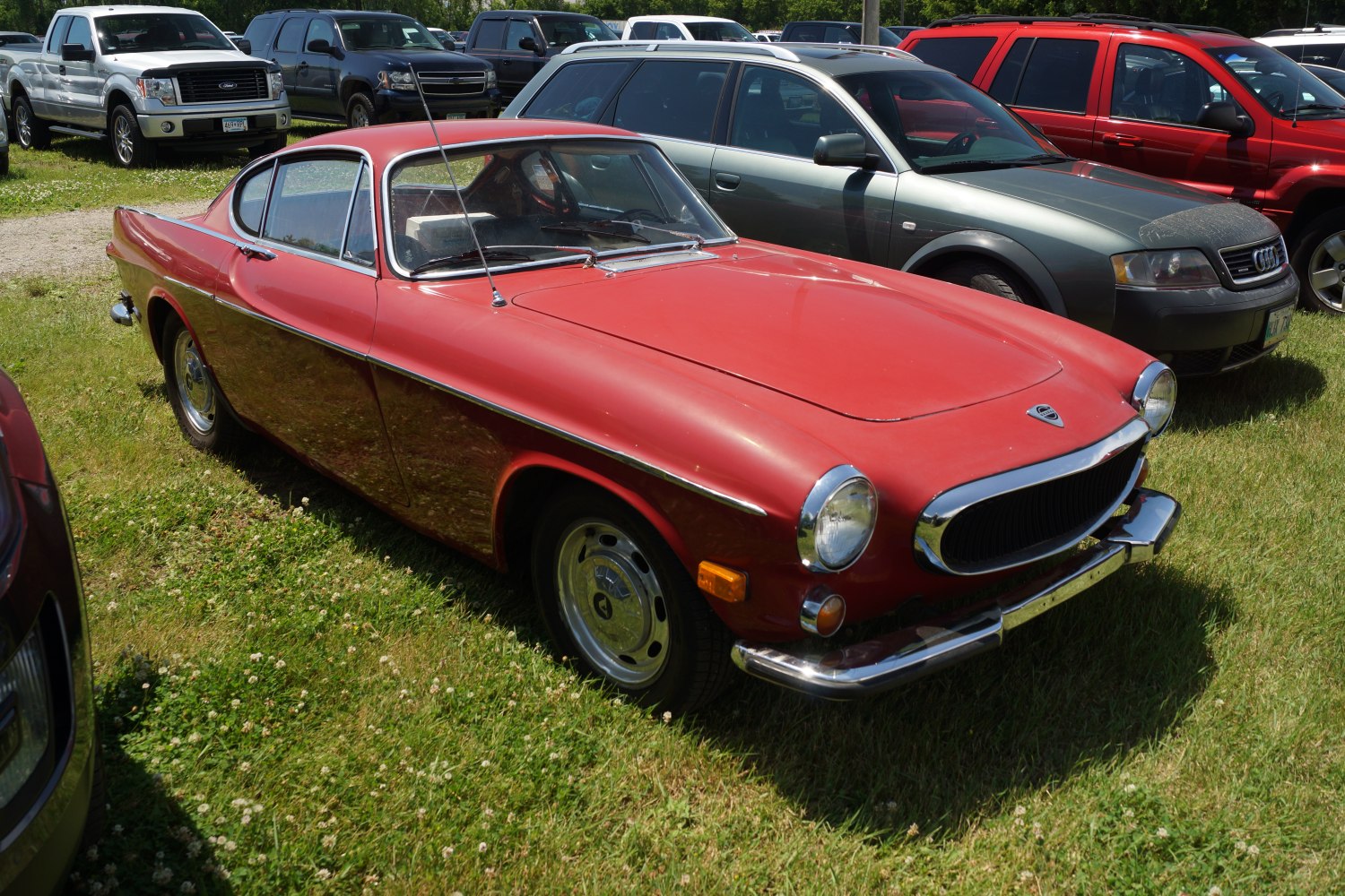 Vintage red sports coupe with rounded body and chrome grille