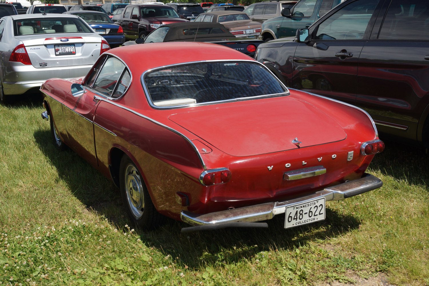 Rear view of a classic red coupe with chrome bumper and vintage taillights