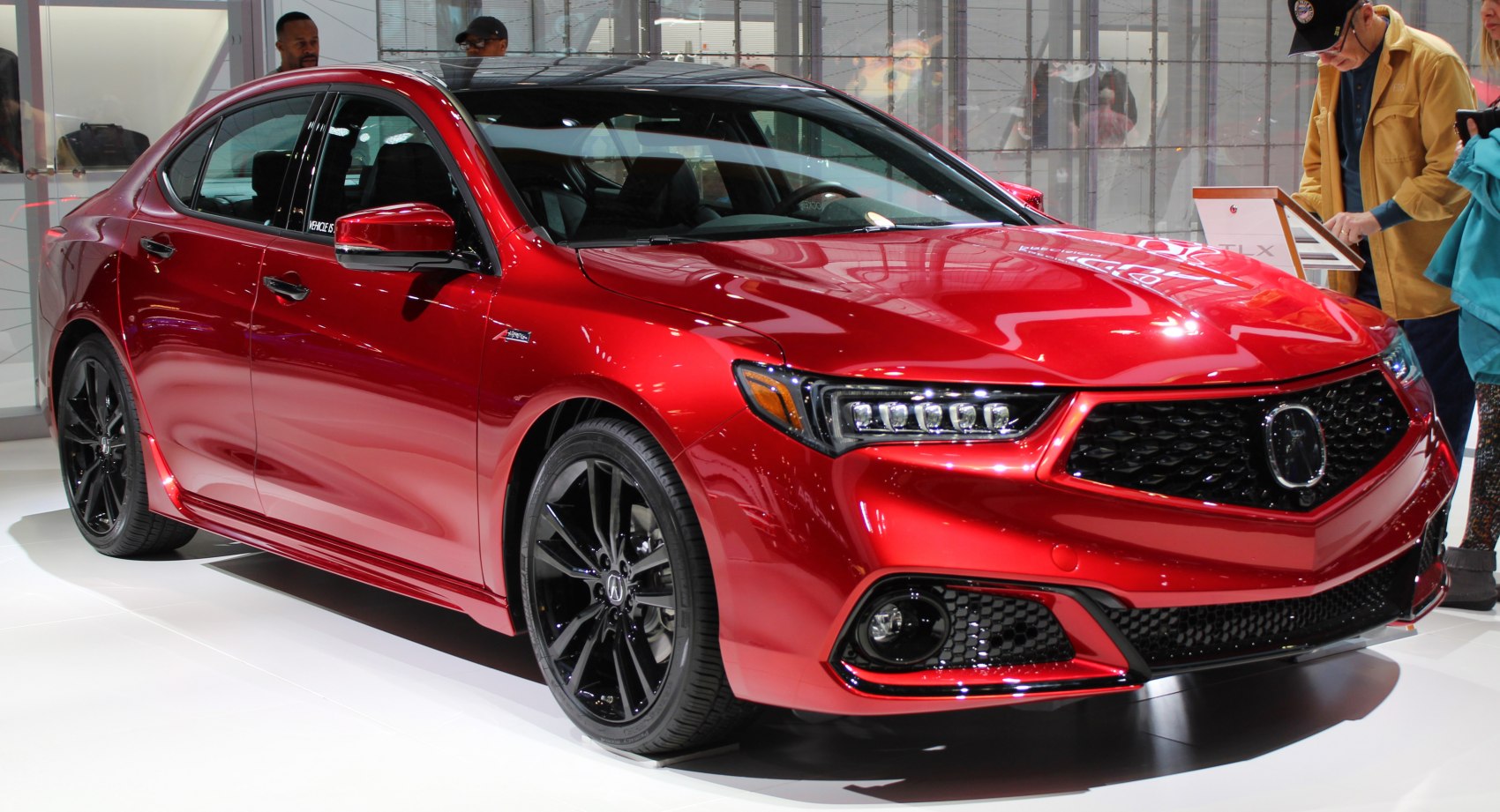 Aggressive front grille and LED headlights on a red sporty sedan.
