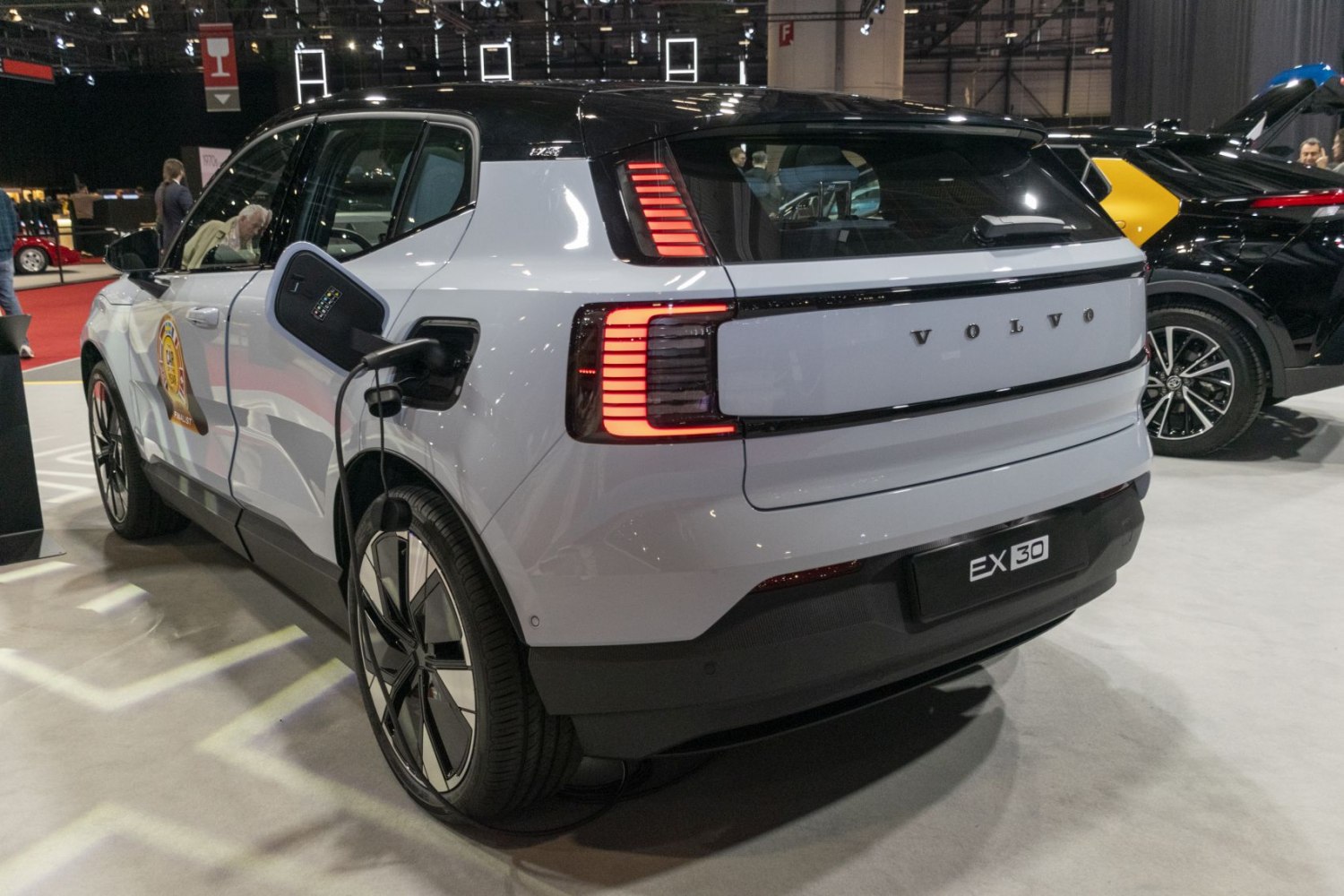 Electric SUV rear view with LED taillights and charging port in use