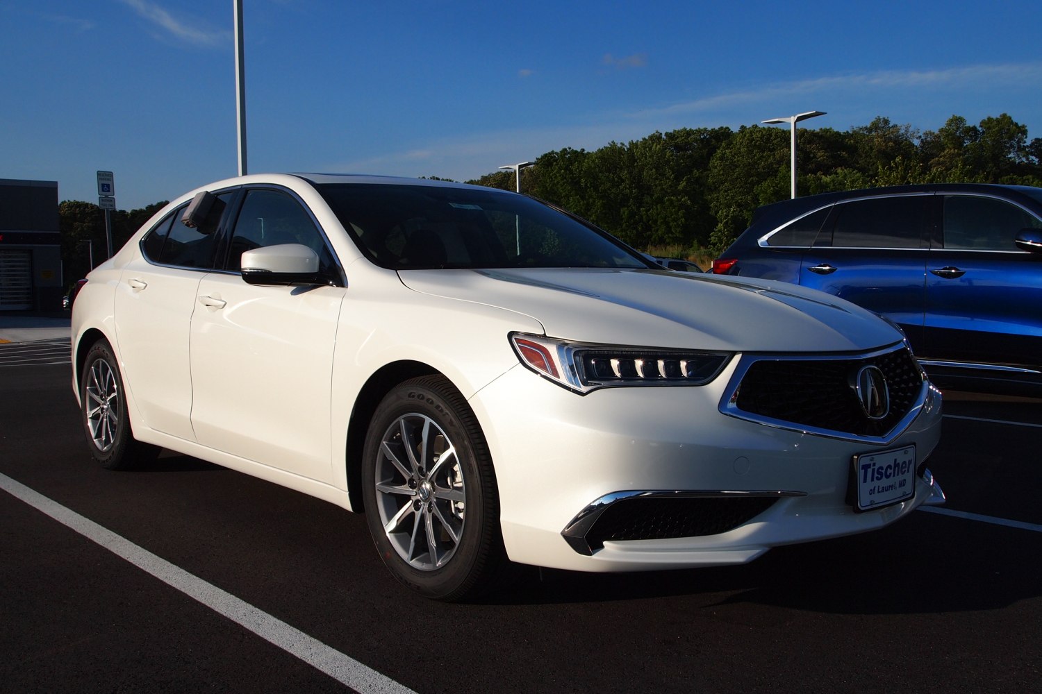 White mid-size sedan with LED headlights and alloy wheels