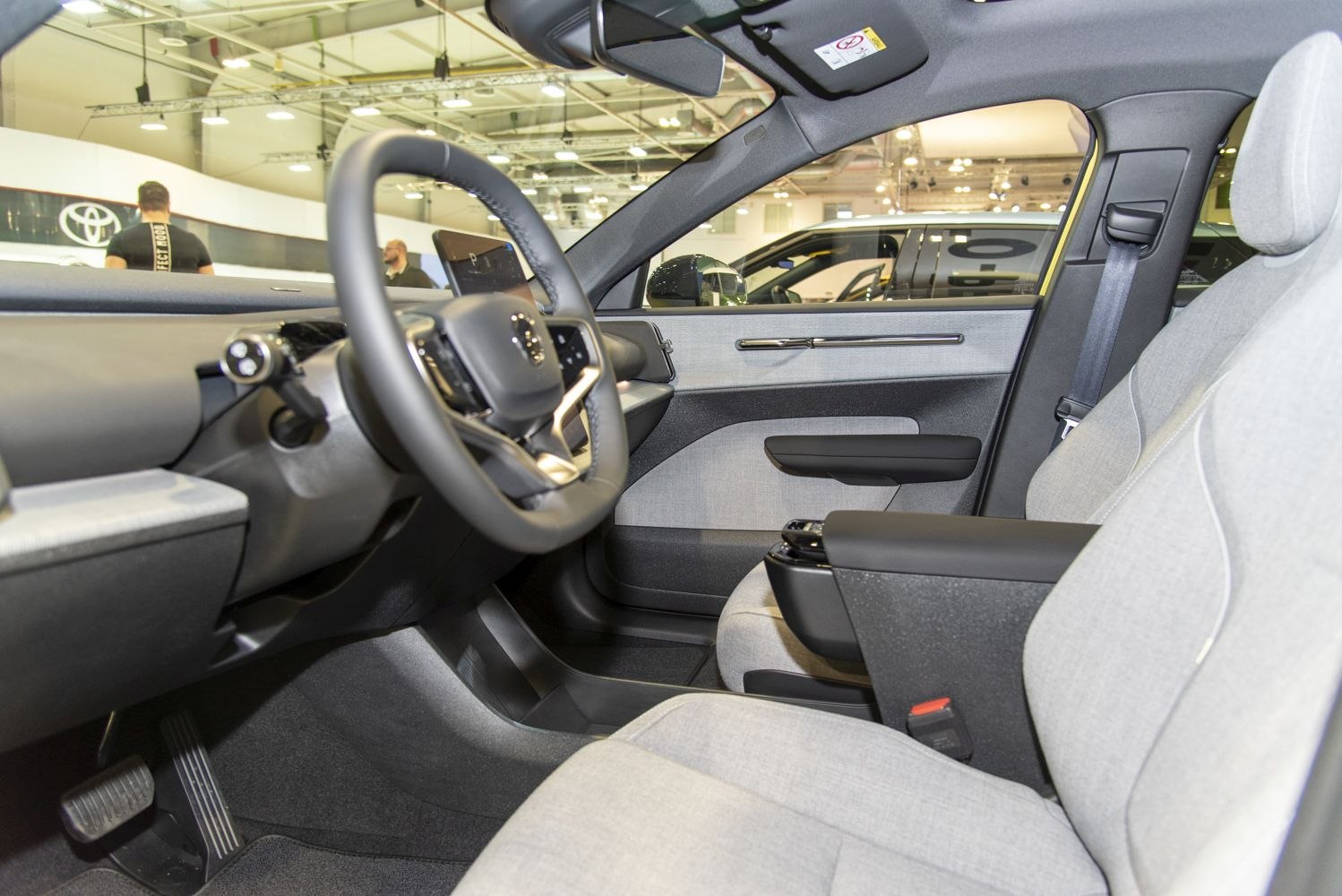 Modern steering wheel and light fabric seats in car interior