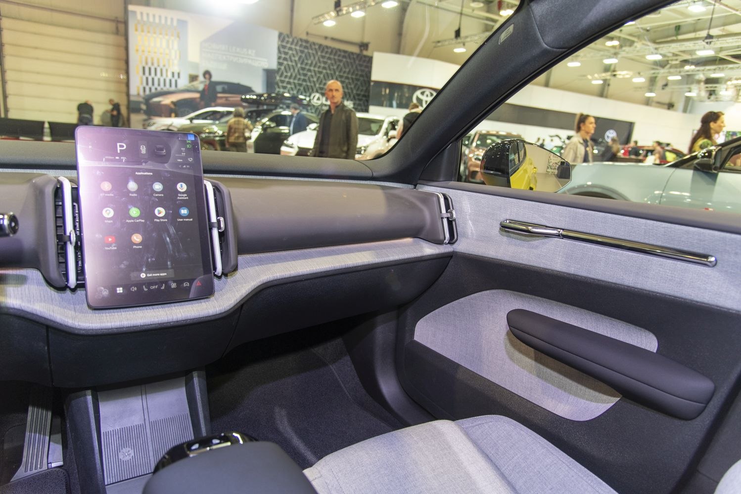 Minimalist car interior with vertical touchscreen display and clean dashboard lines.