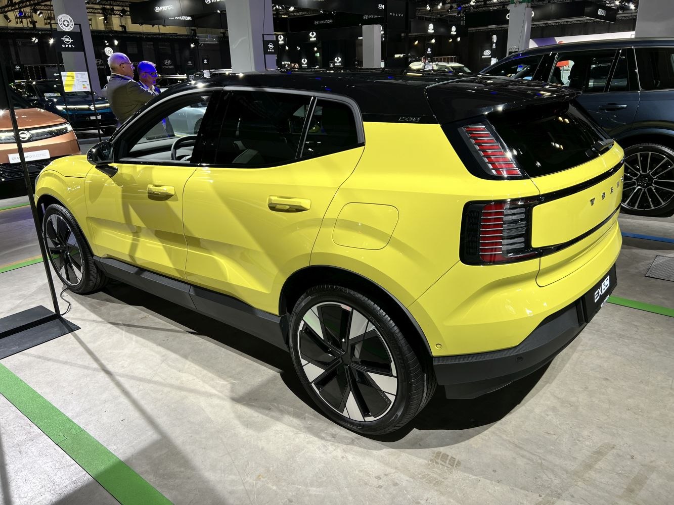 Rear and side profile of a yellow SUV with black roof and distinctive tail lights