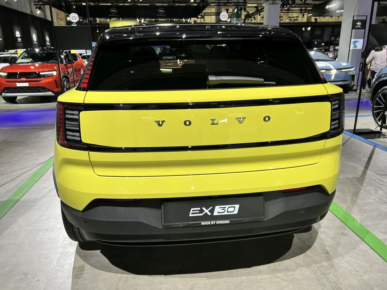 Rear view of a compact electric SUV with distinctive LED tail lights and yellow body.