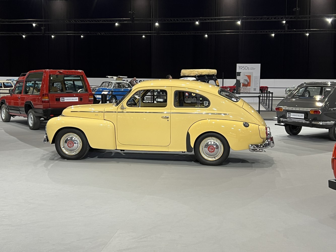 Side view of vintage yellow sedan with chrome bumpers and rounded body.