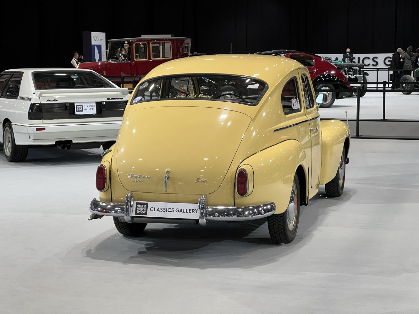 Rounded rear design and vintage tail lamps of a yellow classic car