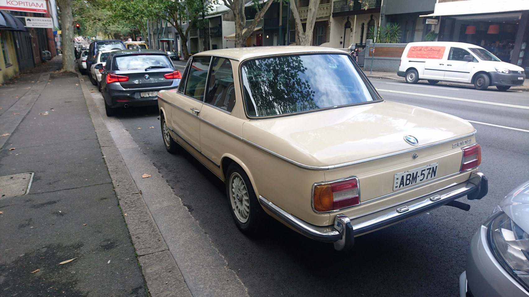 Rear view of a vintage classic BMW 02 with iconic tail lights and chrome bumper.