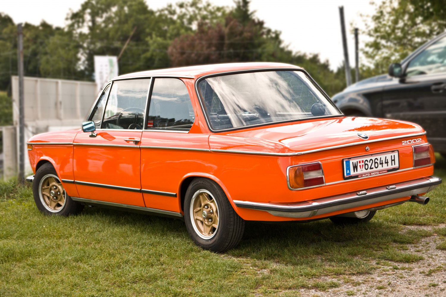 Rear side profile with orange paint and gold alloy wheels