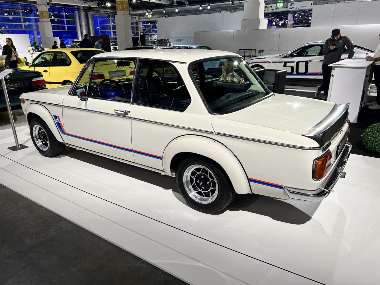 White vintage sport sedan with rear spoiler and flared wheel arches