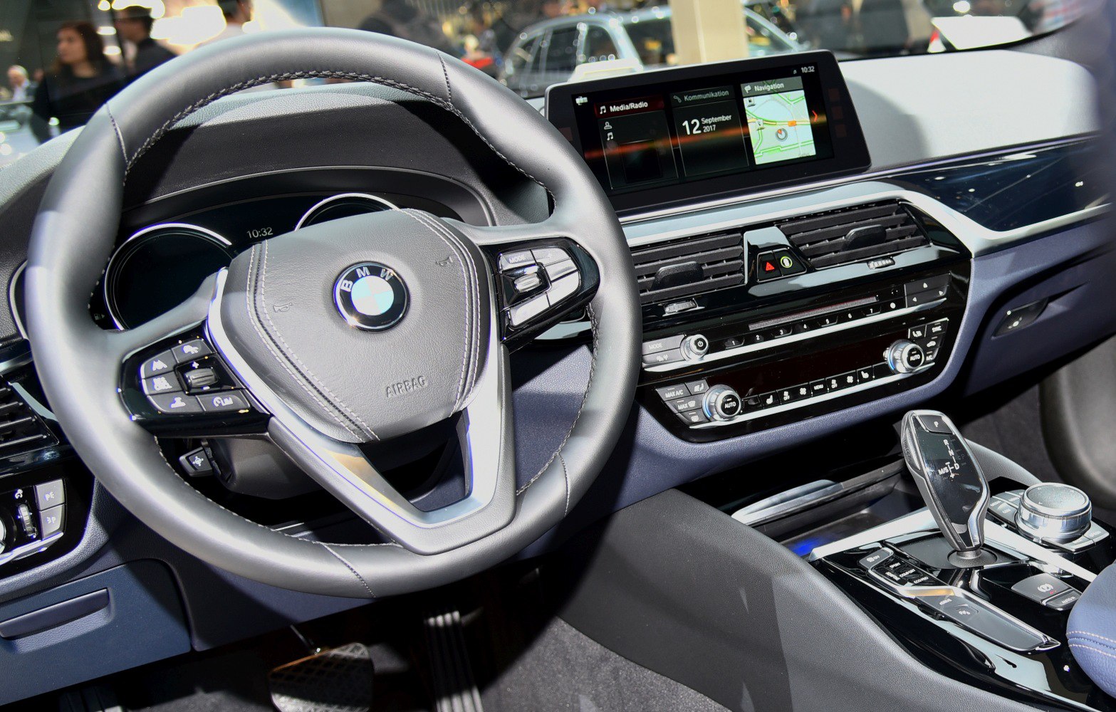 BMW 5 Series G30 interior with dashboard, steering wheel, and multimedia system.