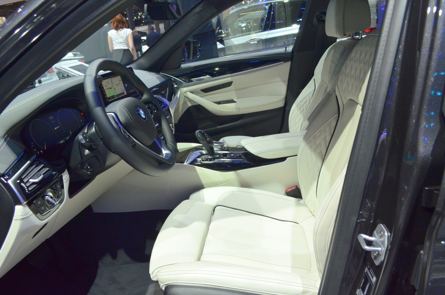 Luxury beige leather seats and advanced BMW dashboard with steering wheel.