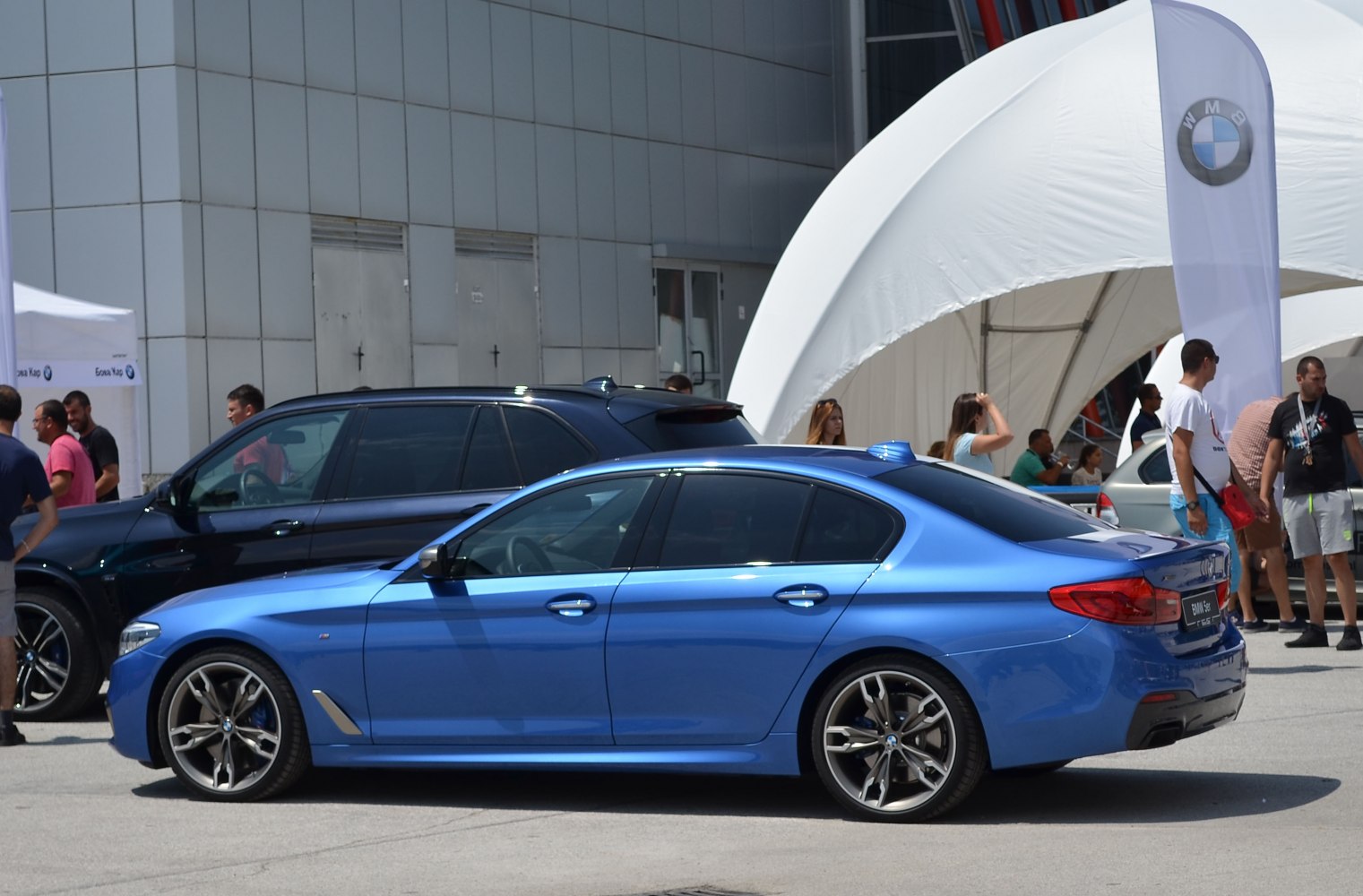 Blue luxury sedan with streamlined side profile and sporty alloy wheels
