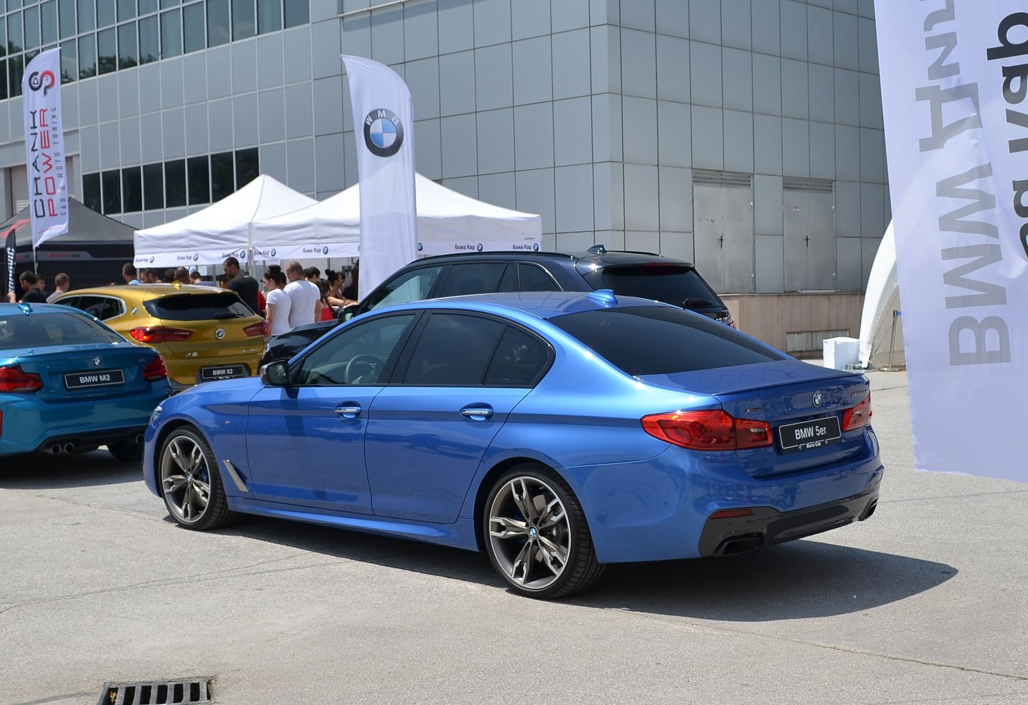 Rear side view of blue sedan with sporty wheels