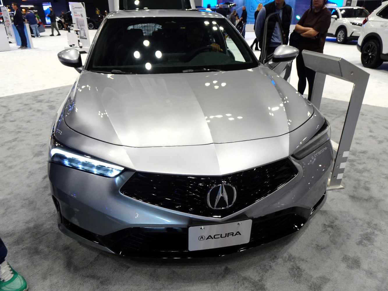 Front view of a silver car with LED headlights and black grille