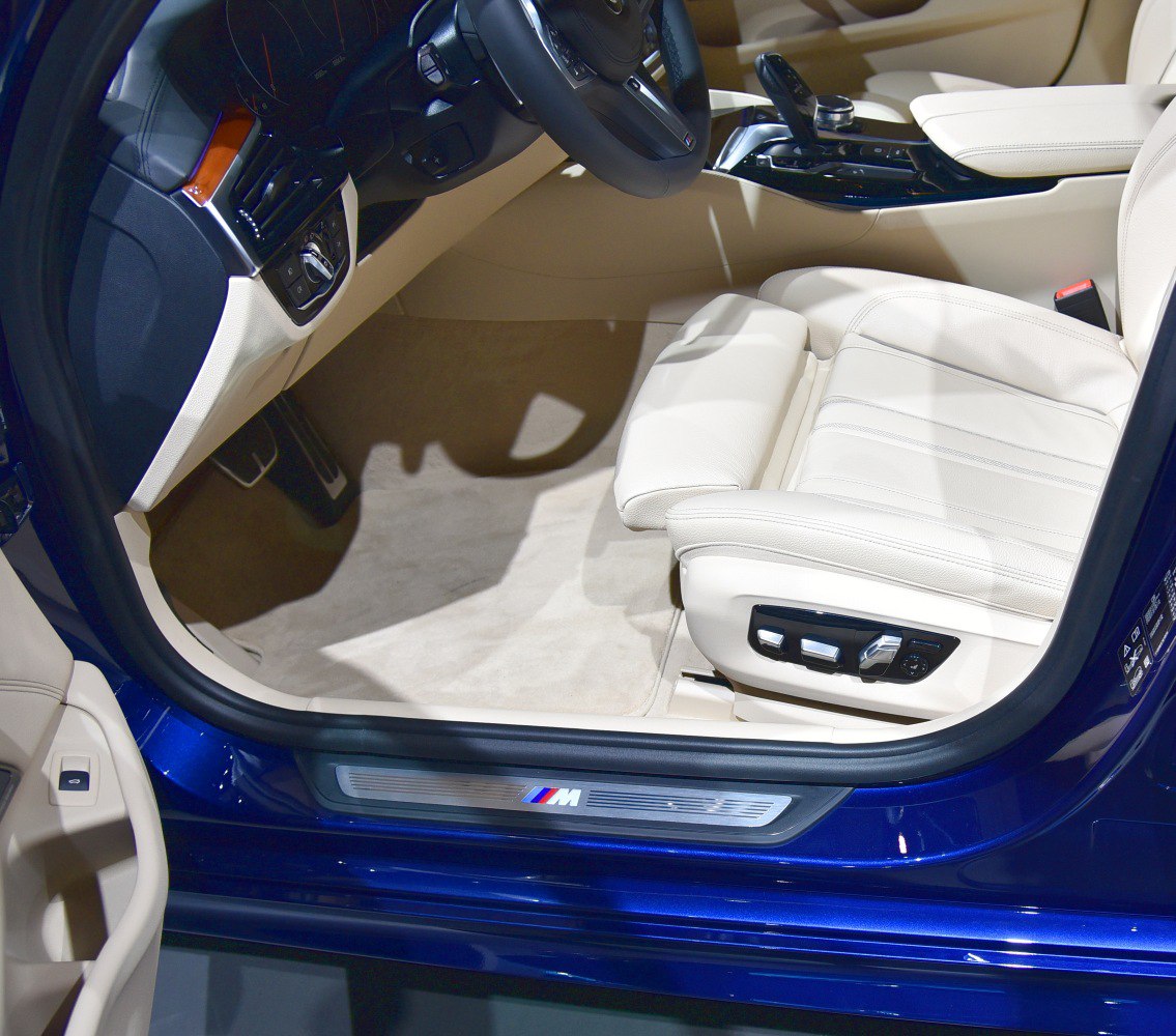 Beige leather front seat with power adjustment and M badge door sill