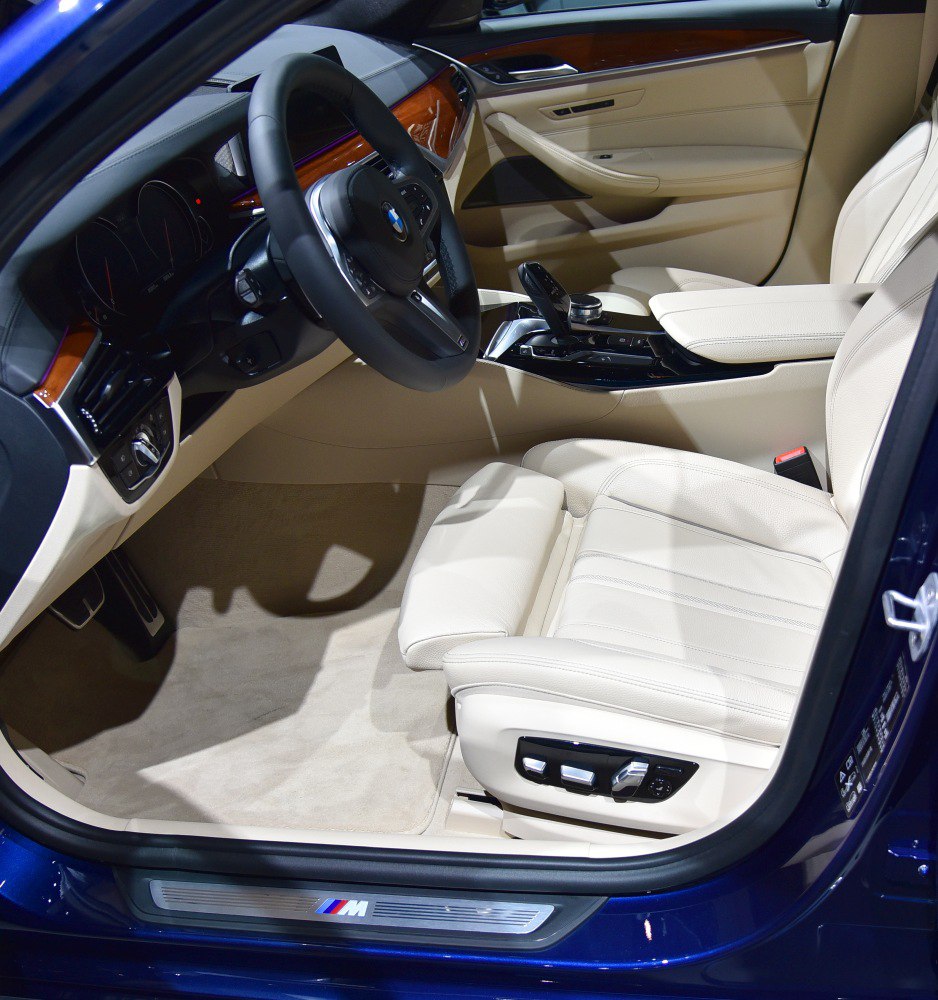 Beige leather driver seat with ergonomic controls and digital dashboard interior