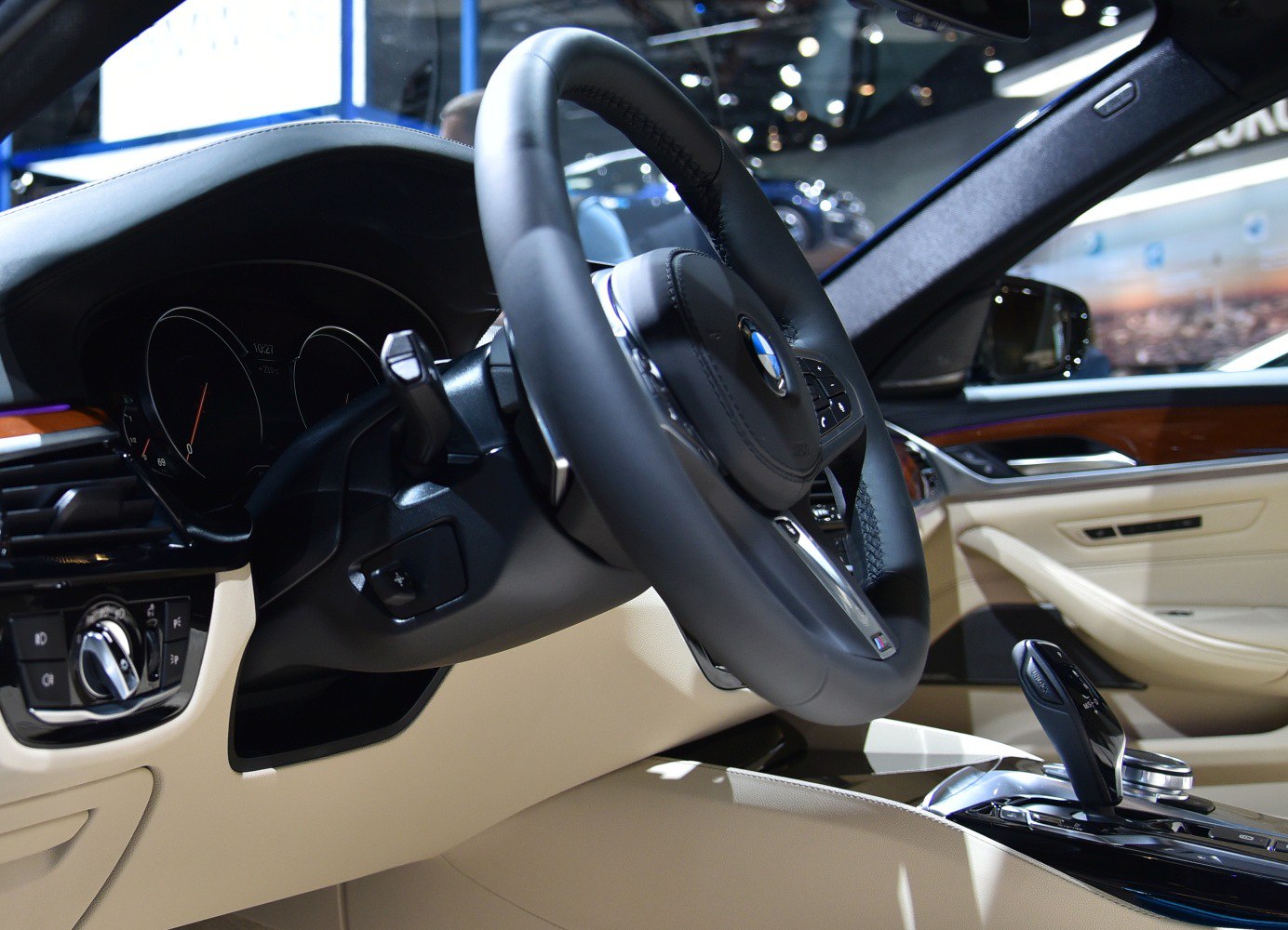 Steering wheel and gear shift in beige luxury car interior