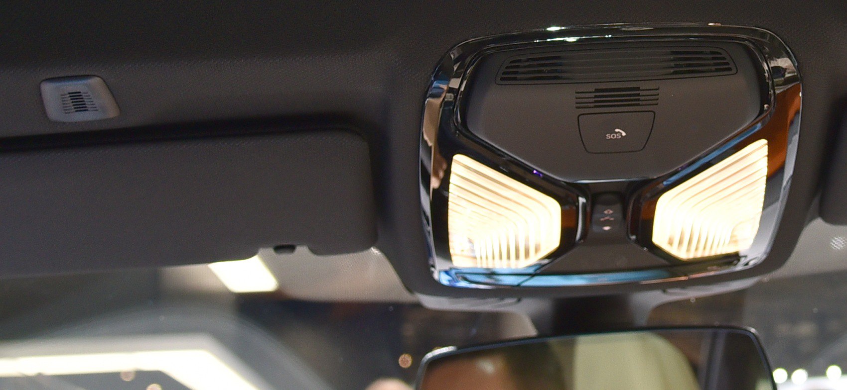 Overhead console with illuminated lights and SOS button in a car interior