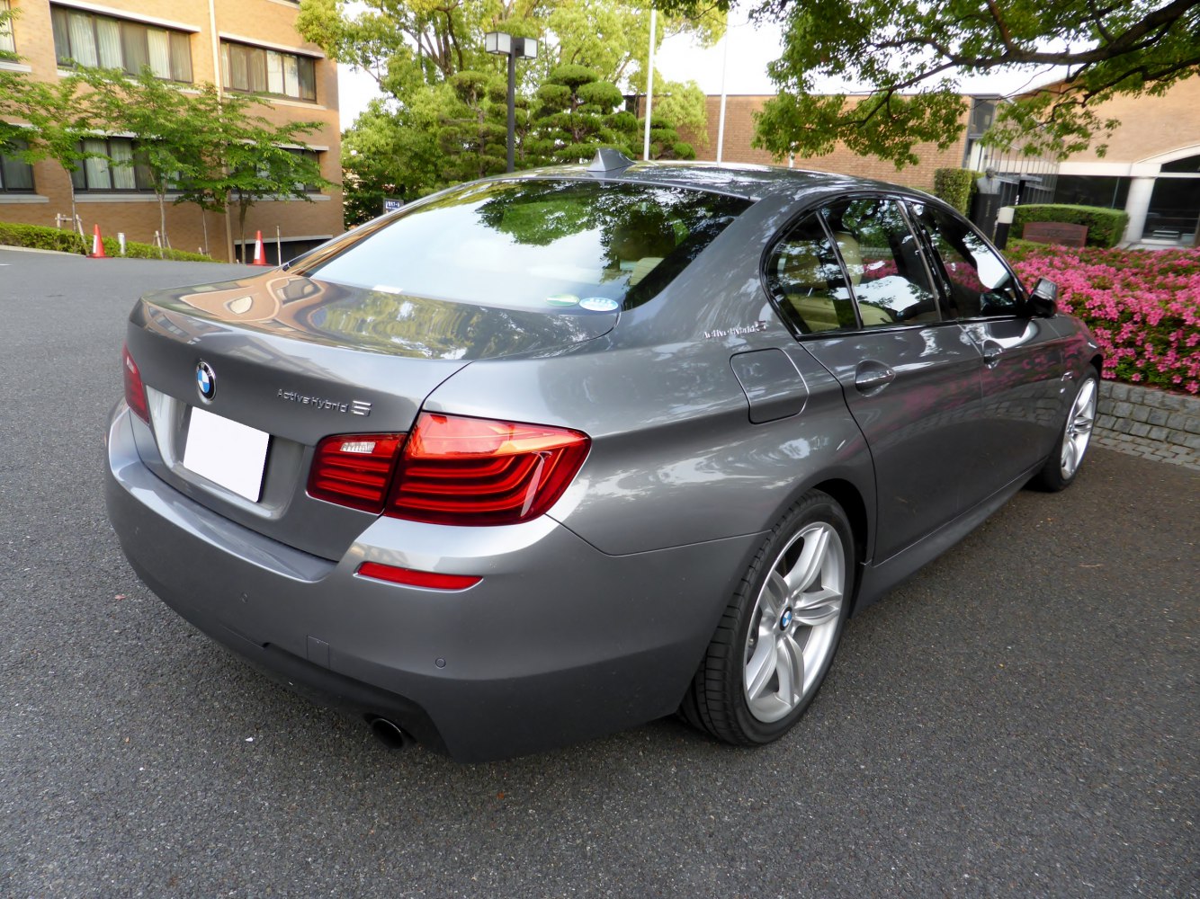 Rear view of a hybrid sedan with prominent tail lights and hybrid badge.