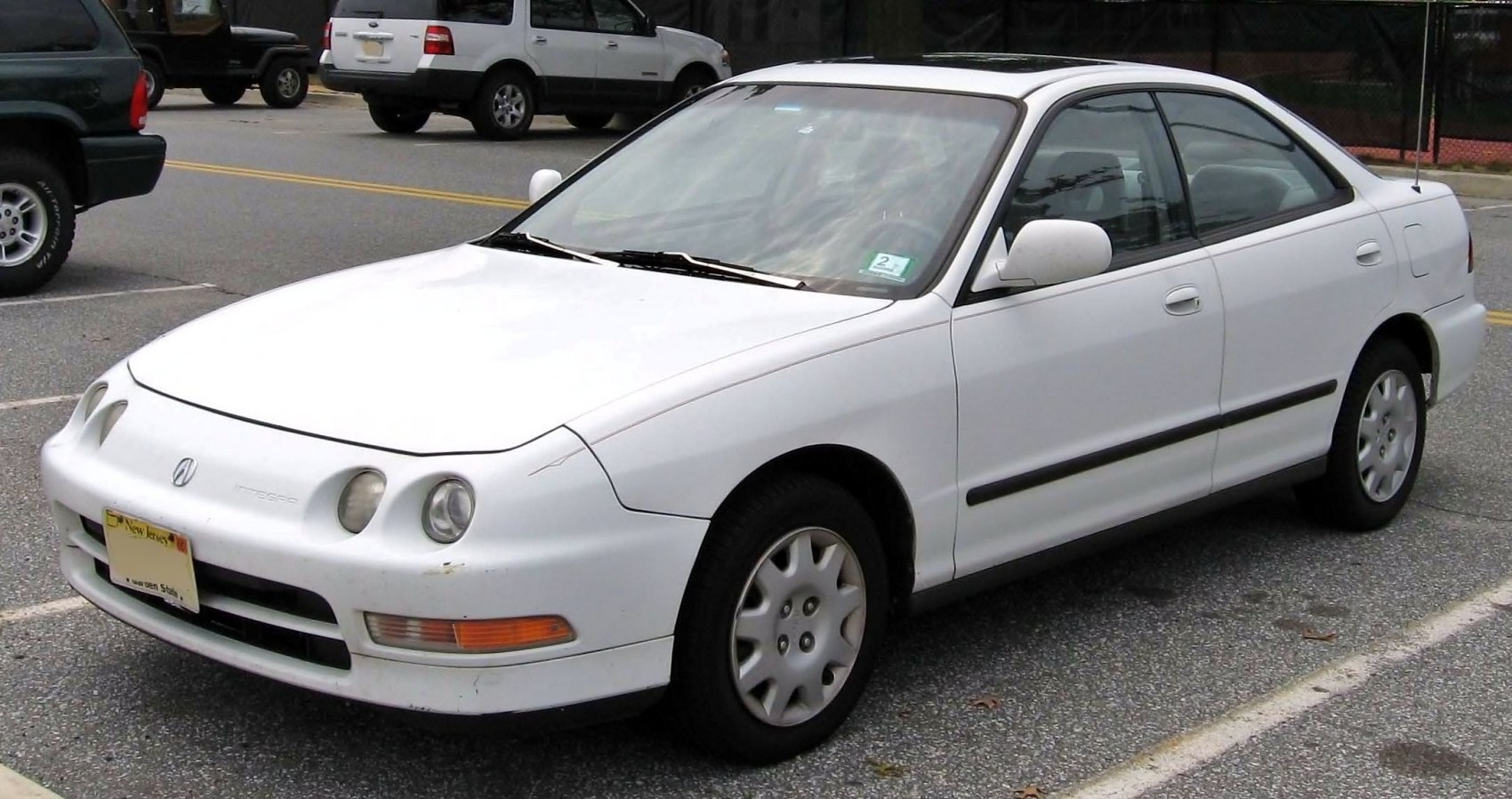 Front side view with round headlights and compact sedan body.