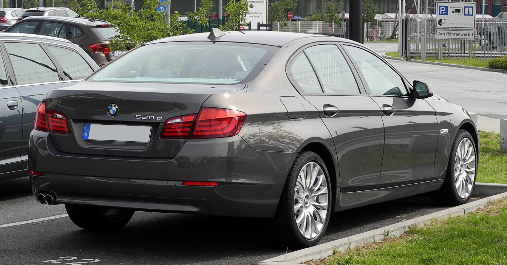 Rear view of a luxury sedan with distinct taillights and 520d badge.