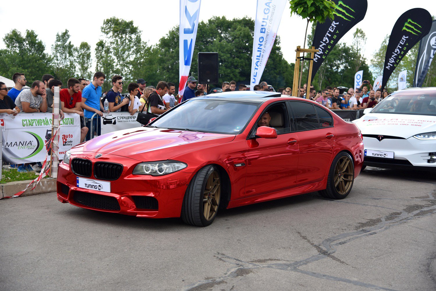 Red BMW sedan with bronze alloy wheels at car event