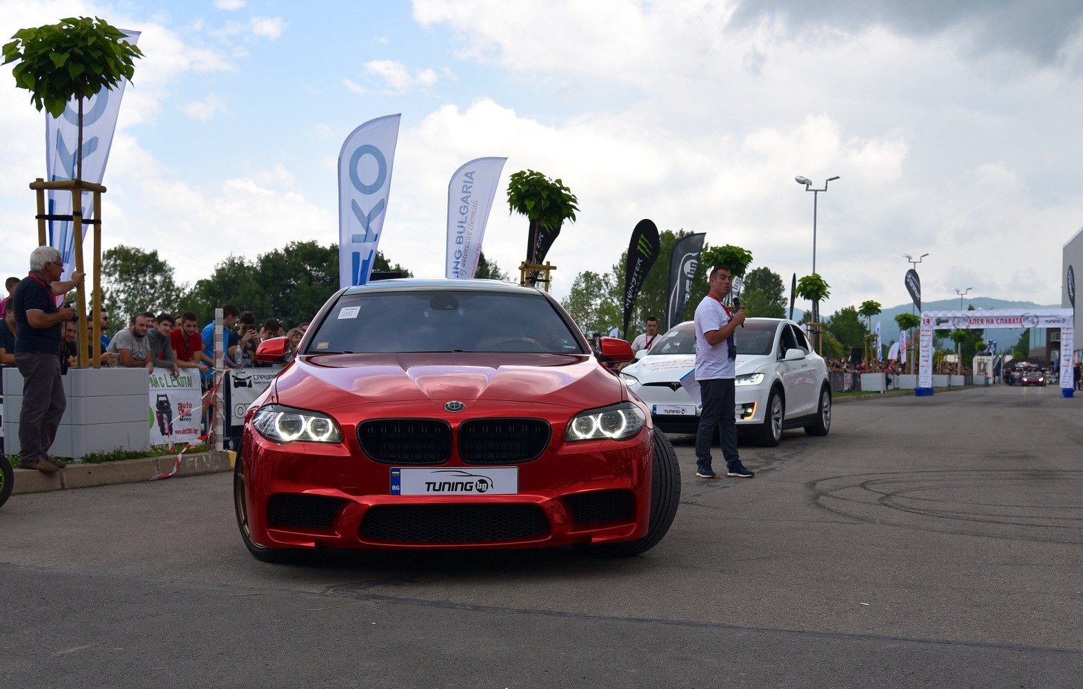 Front view of red luxury sedan with LED angel eyes and kidney grille