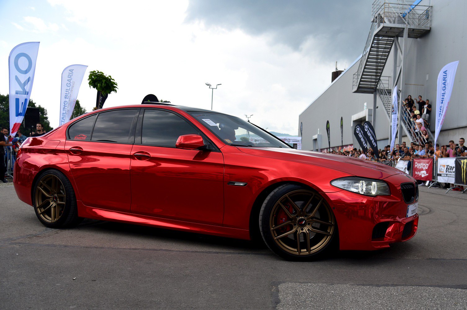Red modified sedan with tinted windows and bronze alloy wheels
