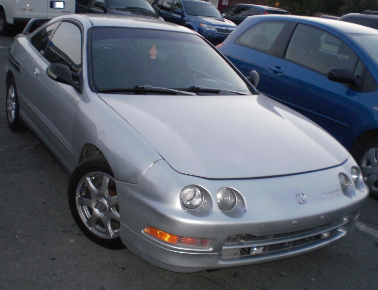 Front-side view of silver coupe with dual round headlights and sporty wheels