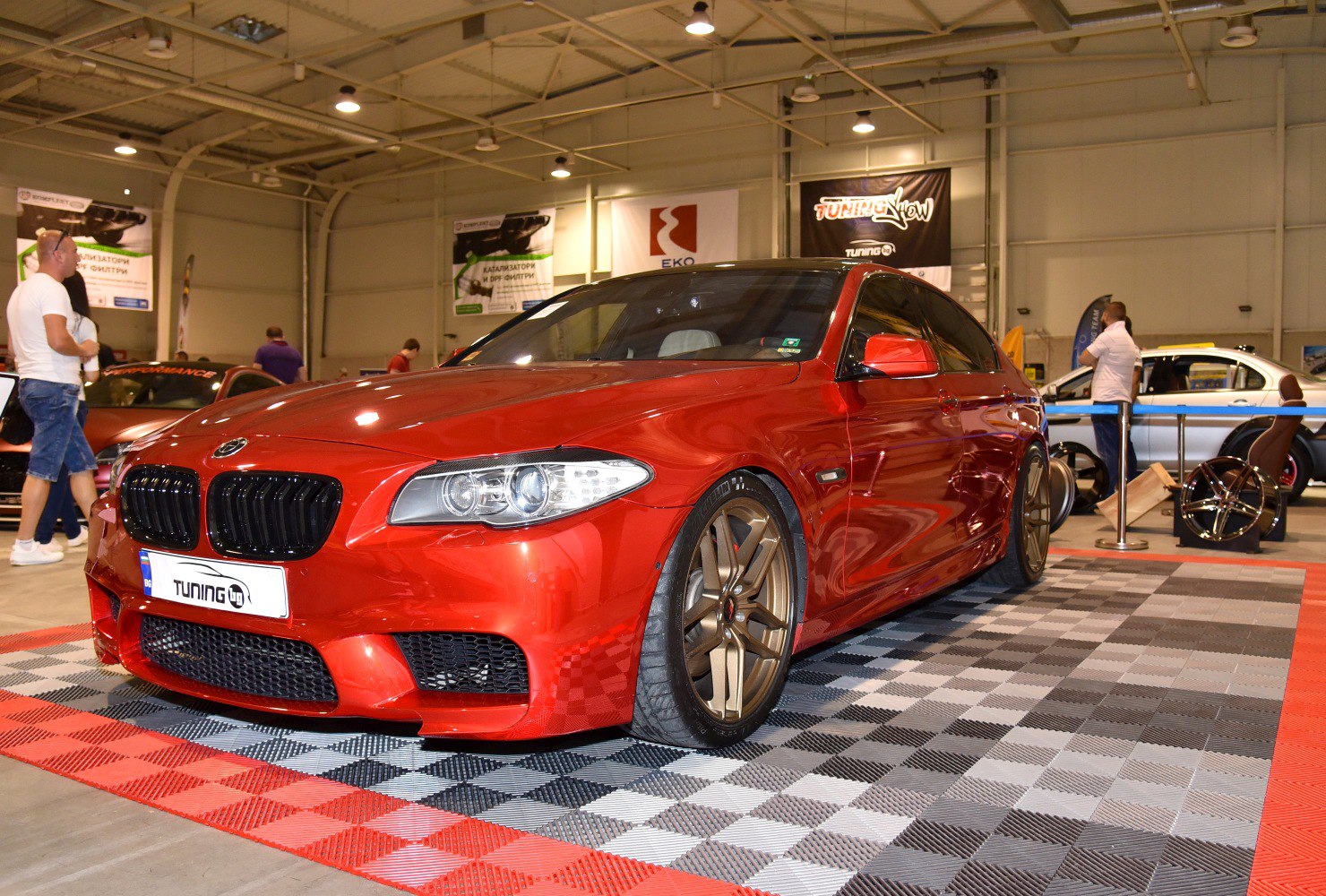 Red sedan with custom bronze alloy wheels and sporty front design