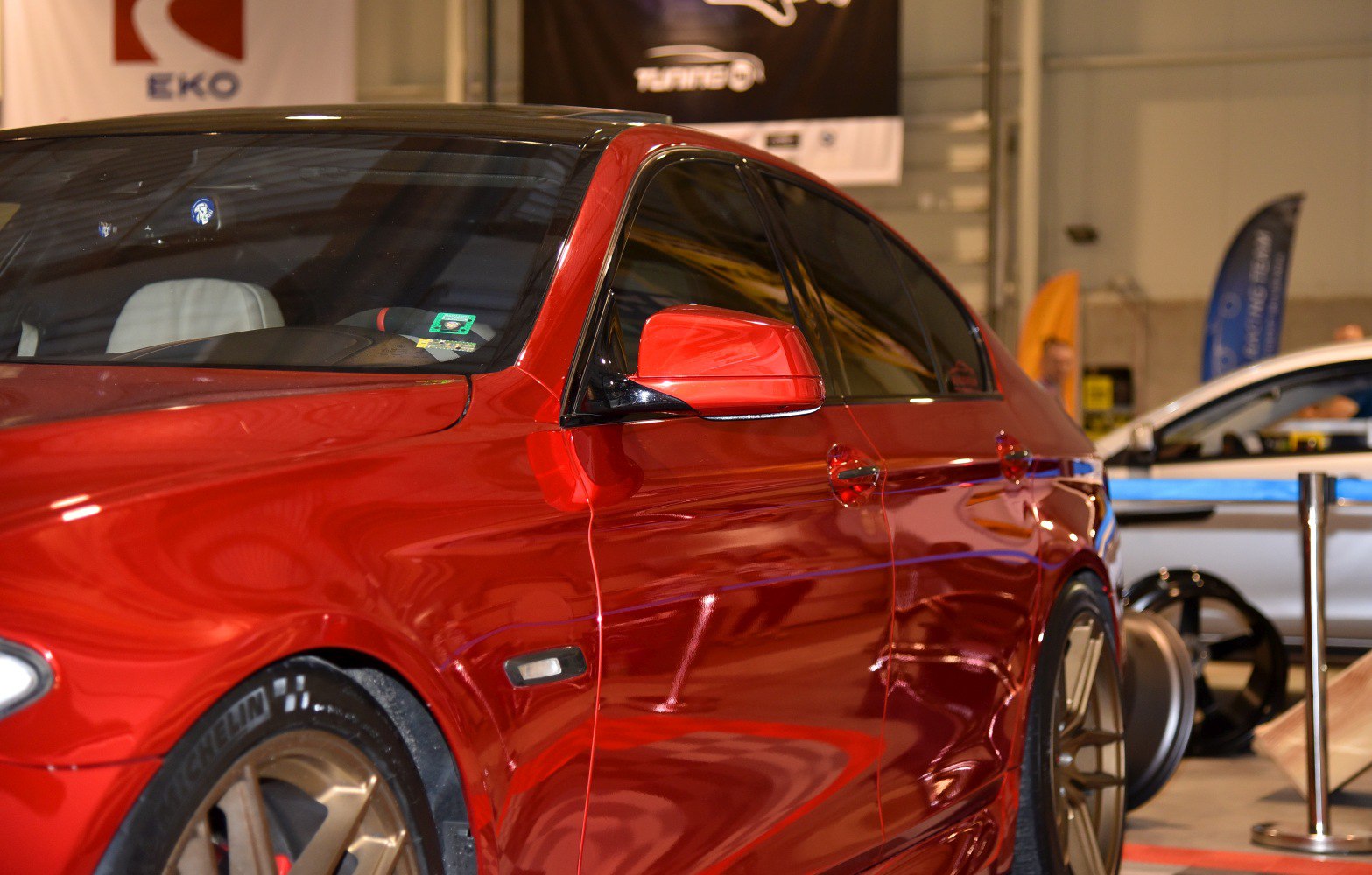 Red sedan side with bronze wheels and tinted windows
