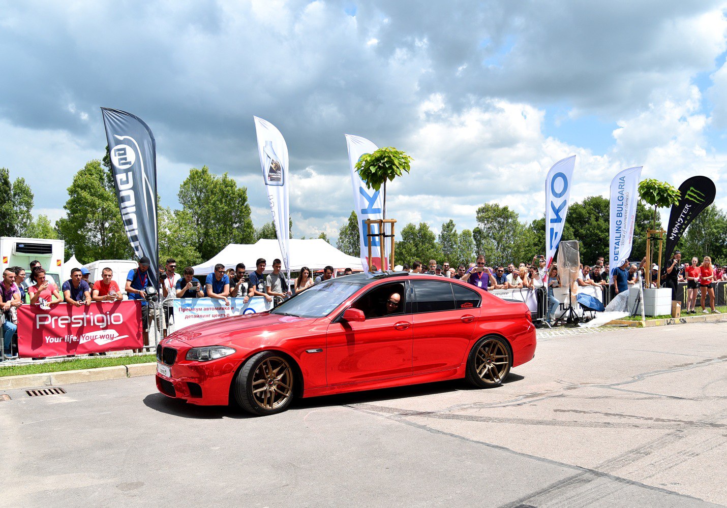 Red sedan with custom bronze wheels and tinted windows