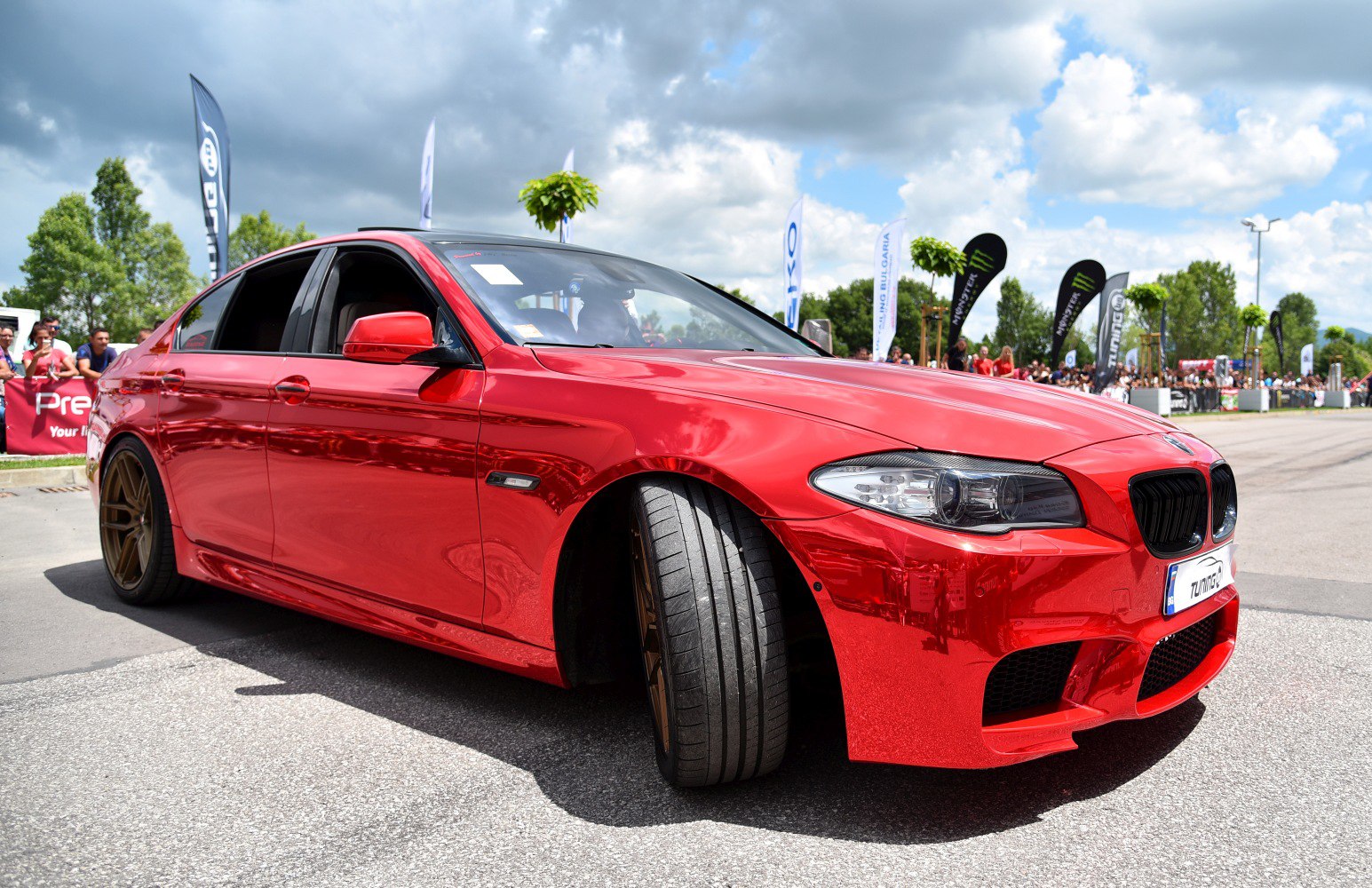 Red luxury sedan with bronze wheels and sporty front design
