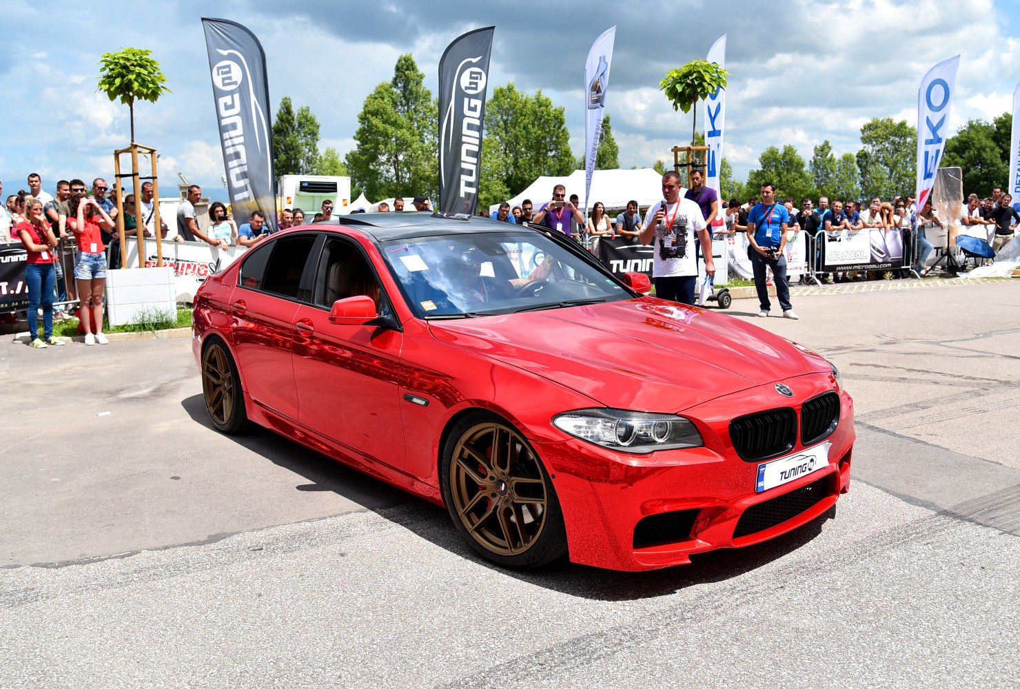 Red sport sedan with bronze wheels and aggressive front design