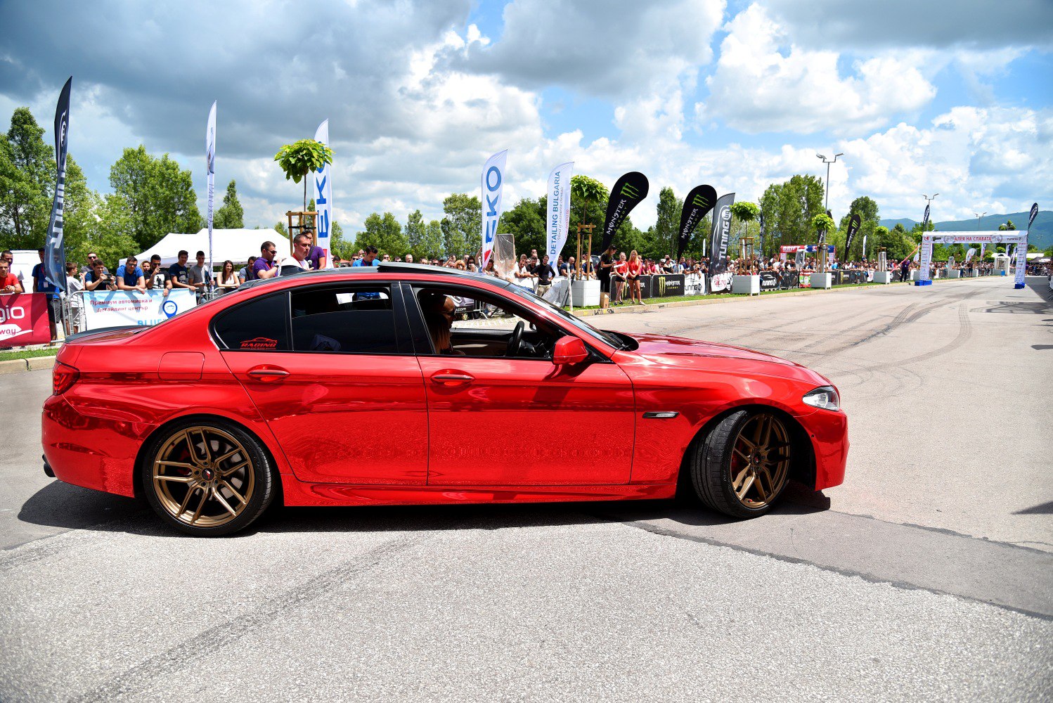 Lowered red sedan with bronze multi-spoke wheels