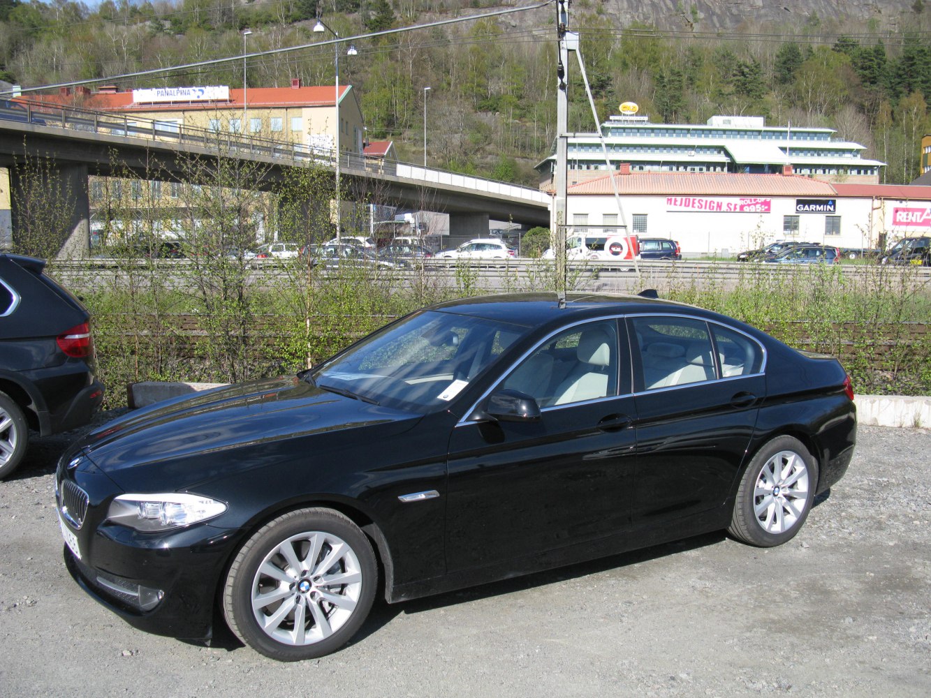 Side profile of black luxury sedan with alloy wheels.
