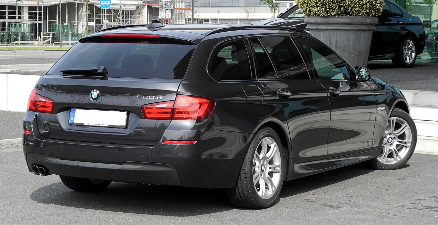 Rear and side view of black station wagon with distinctive taillights and alloy wheels