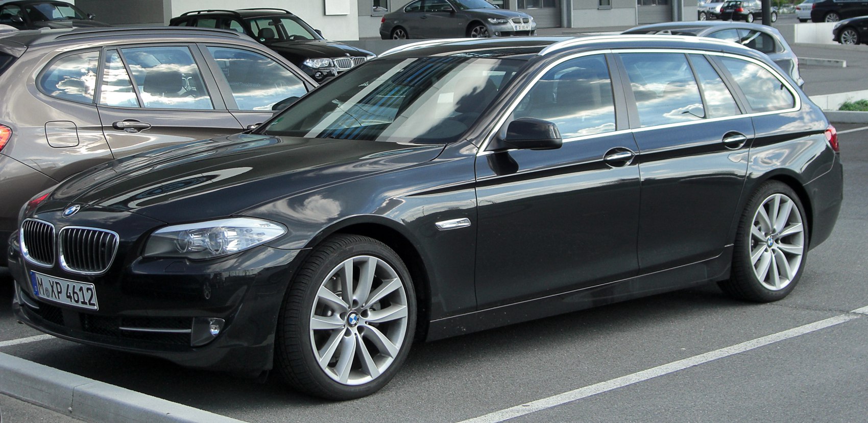 Side view of black mid-size estate with alloy wheels and smooth body lines